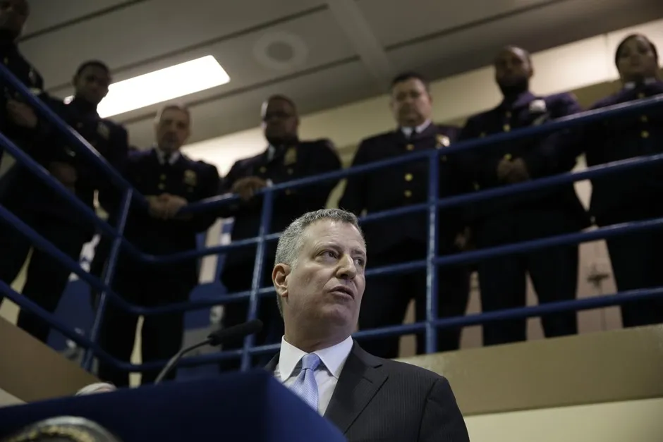 Surrounded by correctional officers, New York City Mayor Bill de Blasio holds a news conference at Rikers Island prison in New York.