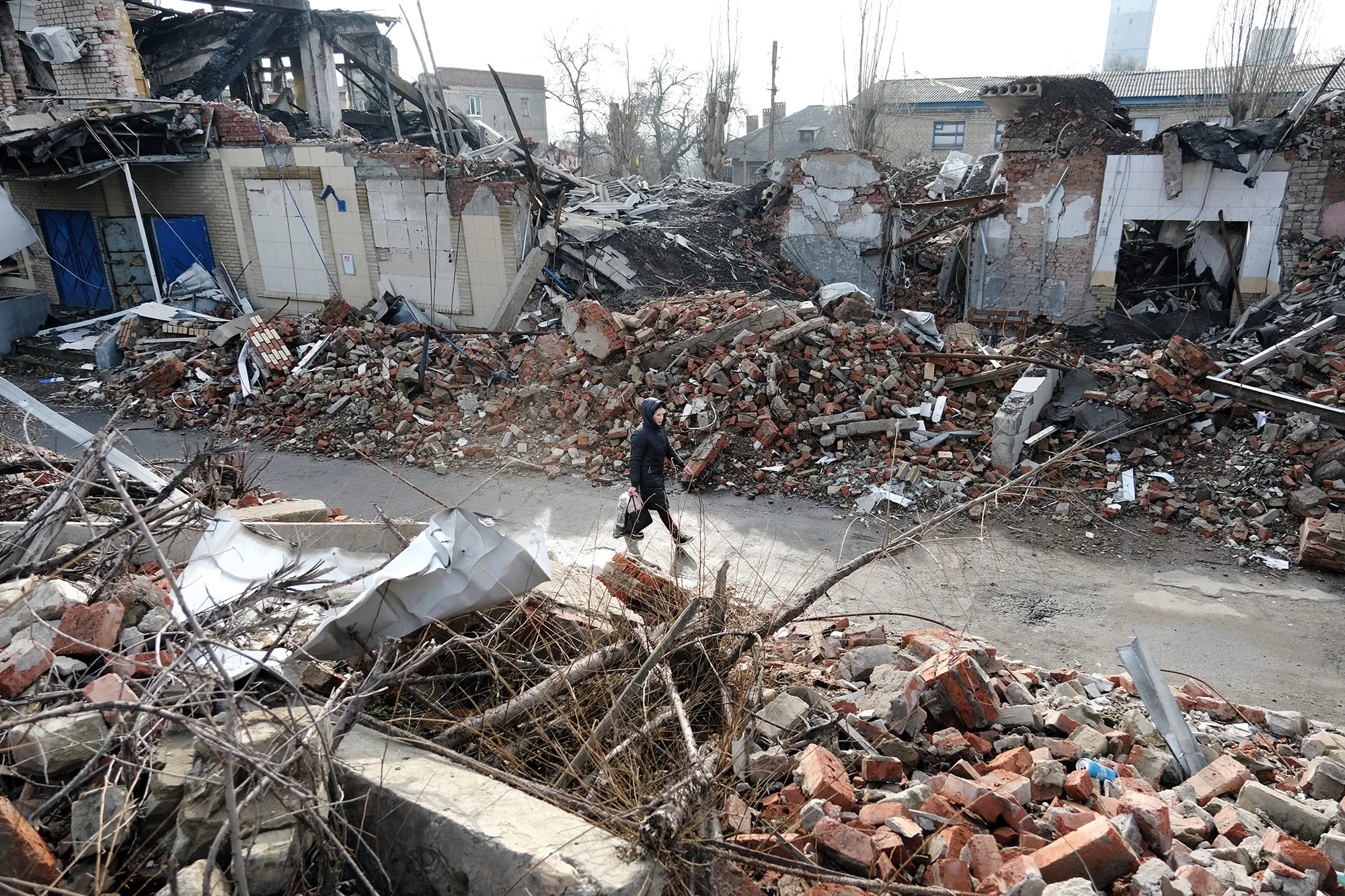 A woman walks by destroyed buildings&nbsp;in the Donetsk Region of&nbsp;Ukraine, on Jan. 20.&nbsp;