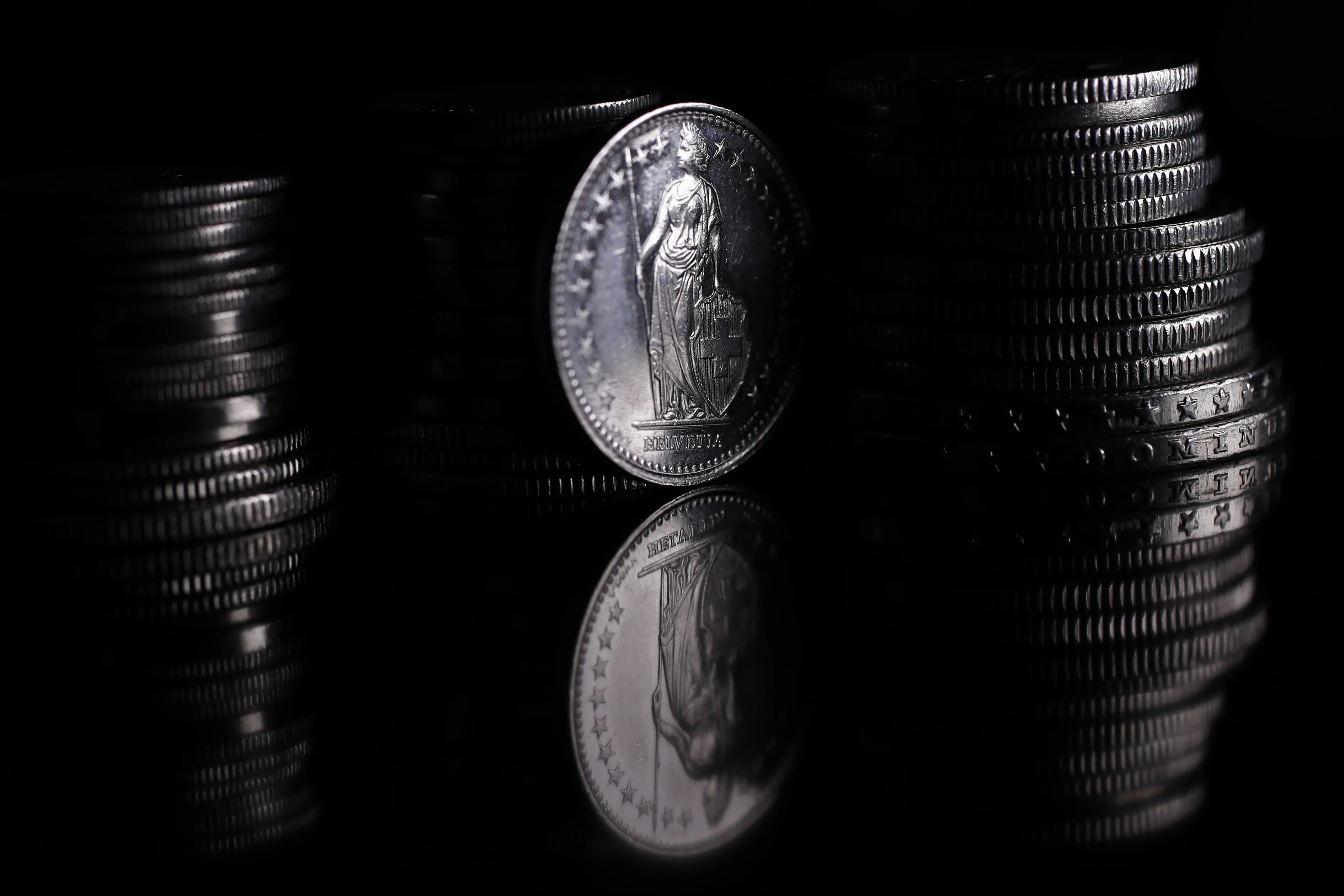 A figure of Helvetia sits on a Swiss franc coin.