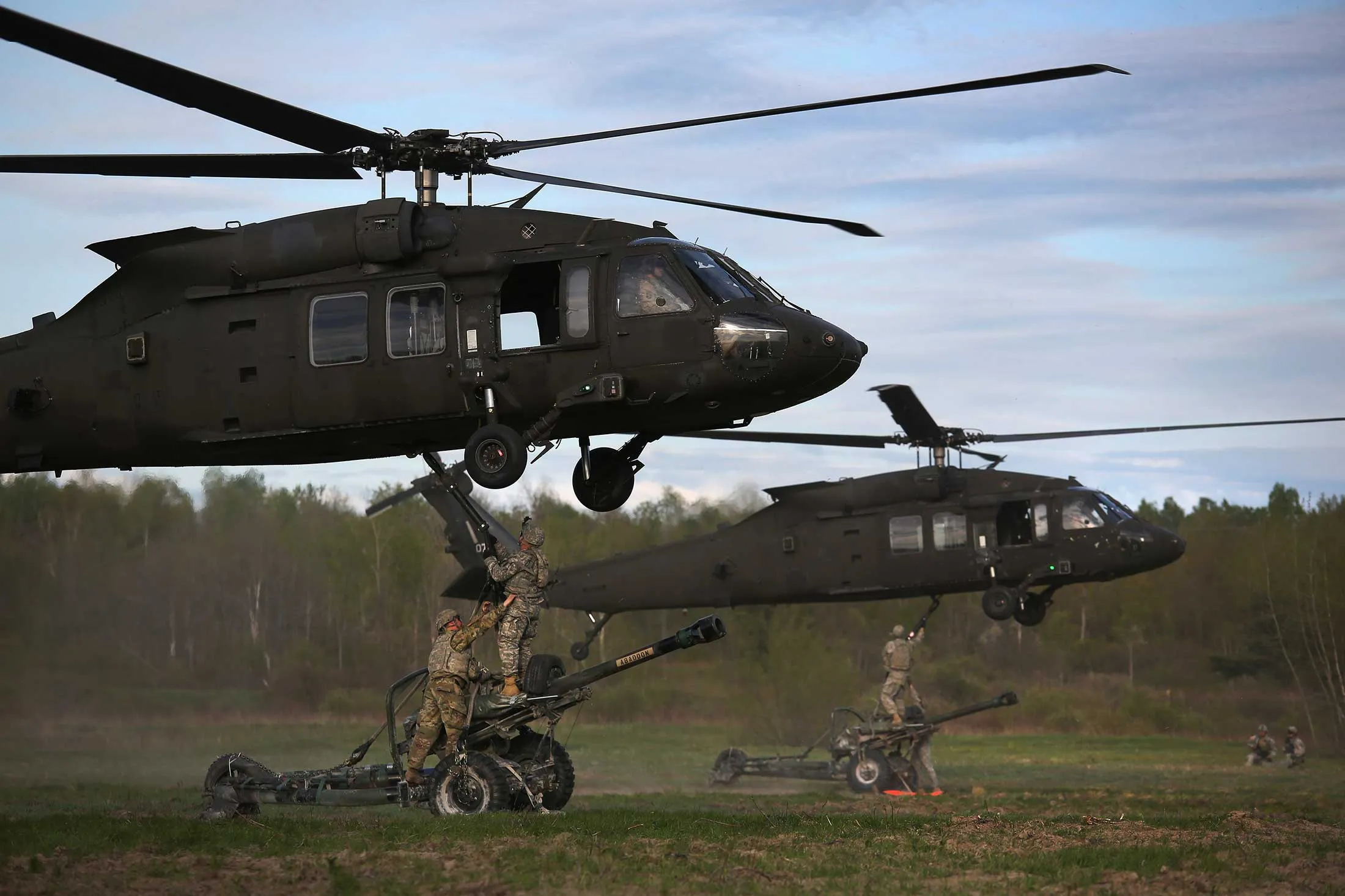 The 10th Mountain Division soldiers hook their 105mm Howitzers to Blackhawk helicopters while on a training mission for future deployments on May 18, 2016 at Fort Drum, New York.
