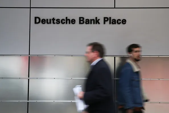 Pedestrians walk past a sign at the Deutsche Bank Place building in Sydney, Australia, on Friday, June 1, 2018. Australia's banking industry faces an unprecedented criminal prosecution as Australia & New Zealand Banking Group Ltd. and two of its underwriters, Deutsche Bank and Citigroup Inc., brace for cartel charges over a A$2.5 billion ($1.9 billion) share sale.