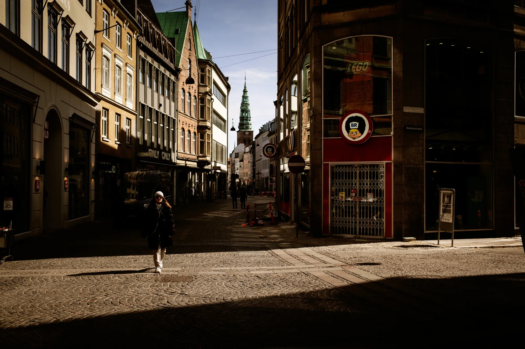 A pedestrian walks past closed stores on Storget street in Copenhagen, Denmark, on April 15.&nbsp;