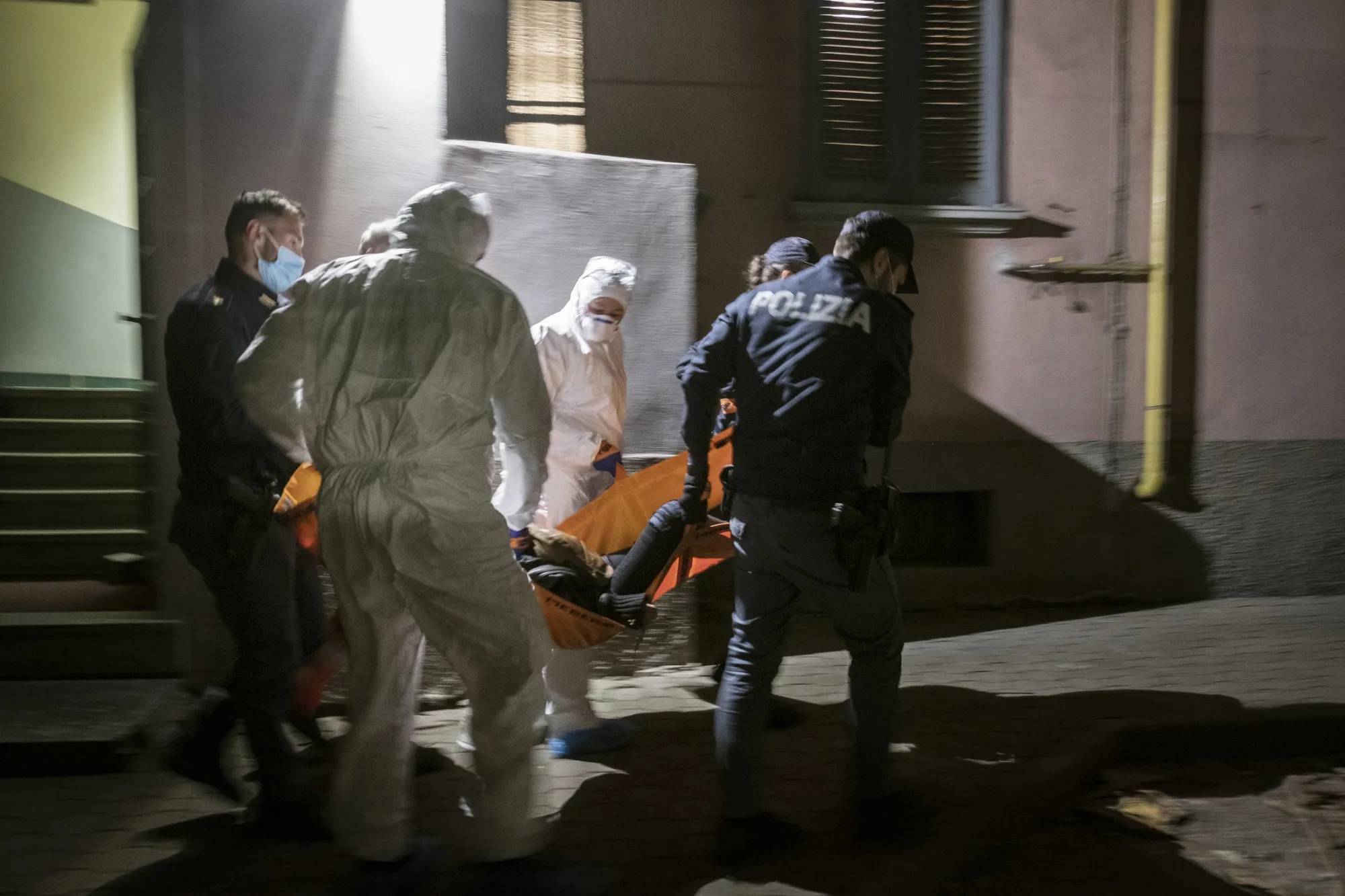 Police officers and medical workers&nbsp;carry a patient&nbsp;in Milan on April 16.