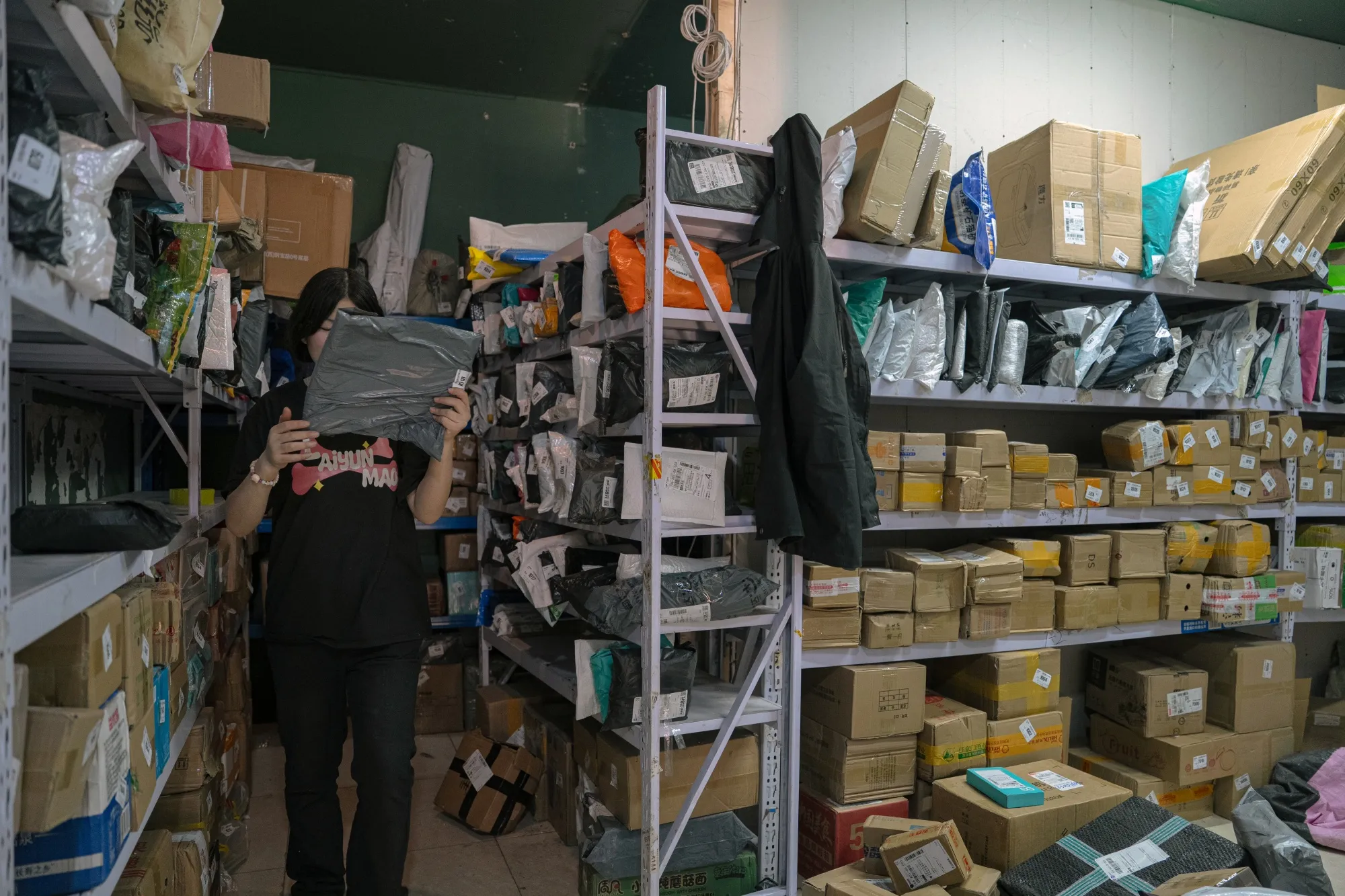 A worker sorts packages at a neighborhood sorting center in Beijing, China.