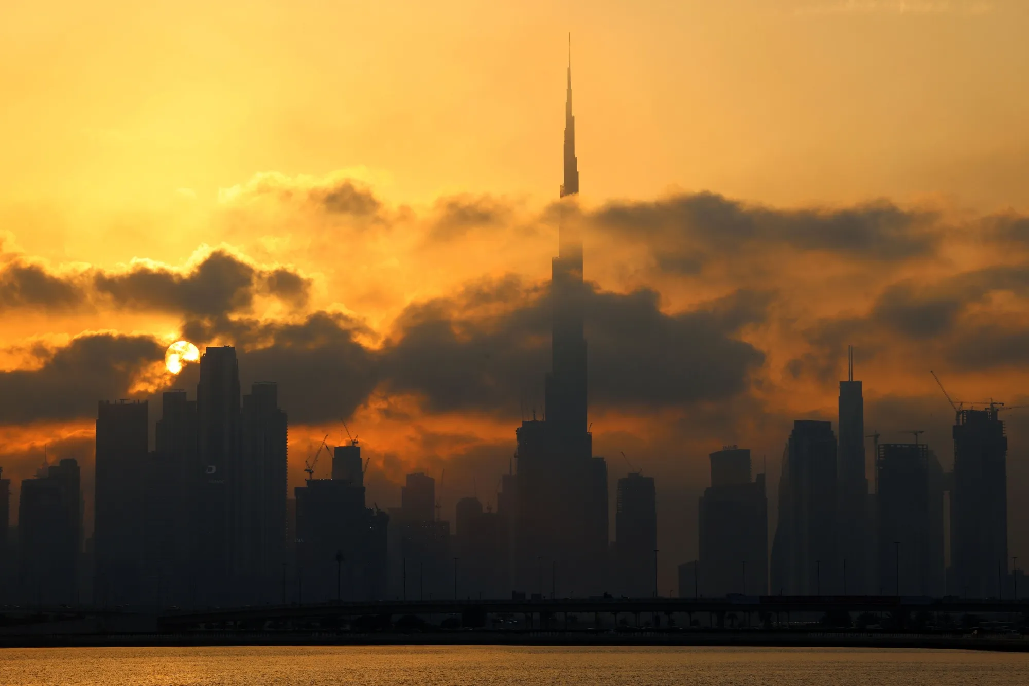 Downtown Dubai skyline with Burj Khalifa, at sunset.