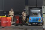 Police officers stand guard at a gas station in Colombo on May 16.