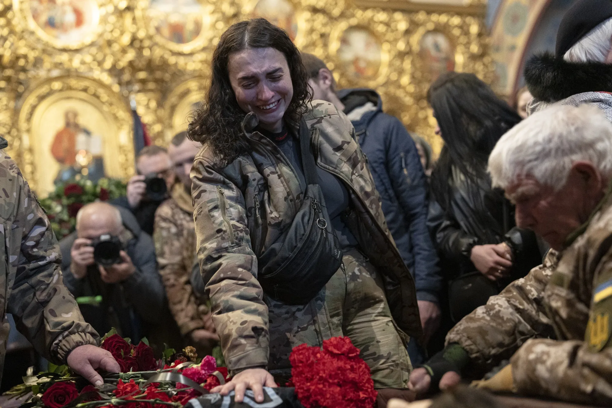Mourners attend the funeral of fallen Ukrainian military commander Dmytro Kotsiubaylo at St. Michael’s Cathedral in Kyiv, Ukraine, on March 10, 2023. Tens of thousands of Ukrainians have been killed by Russian forces, members of which have been accused of war crimes including torture and mass executions.