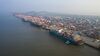 Container ships sit moored next to gantry cranes and containers at the Yangshan Deepwater Port, operated by Shanghai International Port Group Co. (SIPG), in this aerial photograph taken in Shanghai, China, on Wednesday, Aug. 7, 2019. Trump's threat to raise tariffs on all Chinese goods last week shattered a truce reached with Xi just weeks earlier, unleashing tit-for-tat actions on trade and currency policy that risk accelerating a wider geopolitical fight between the world's biggest economies.