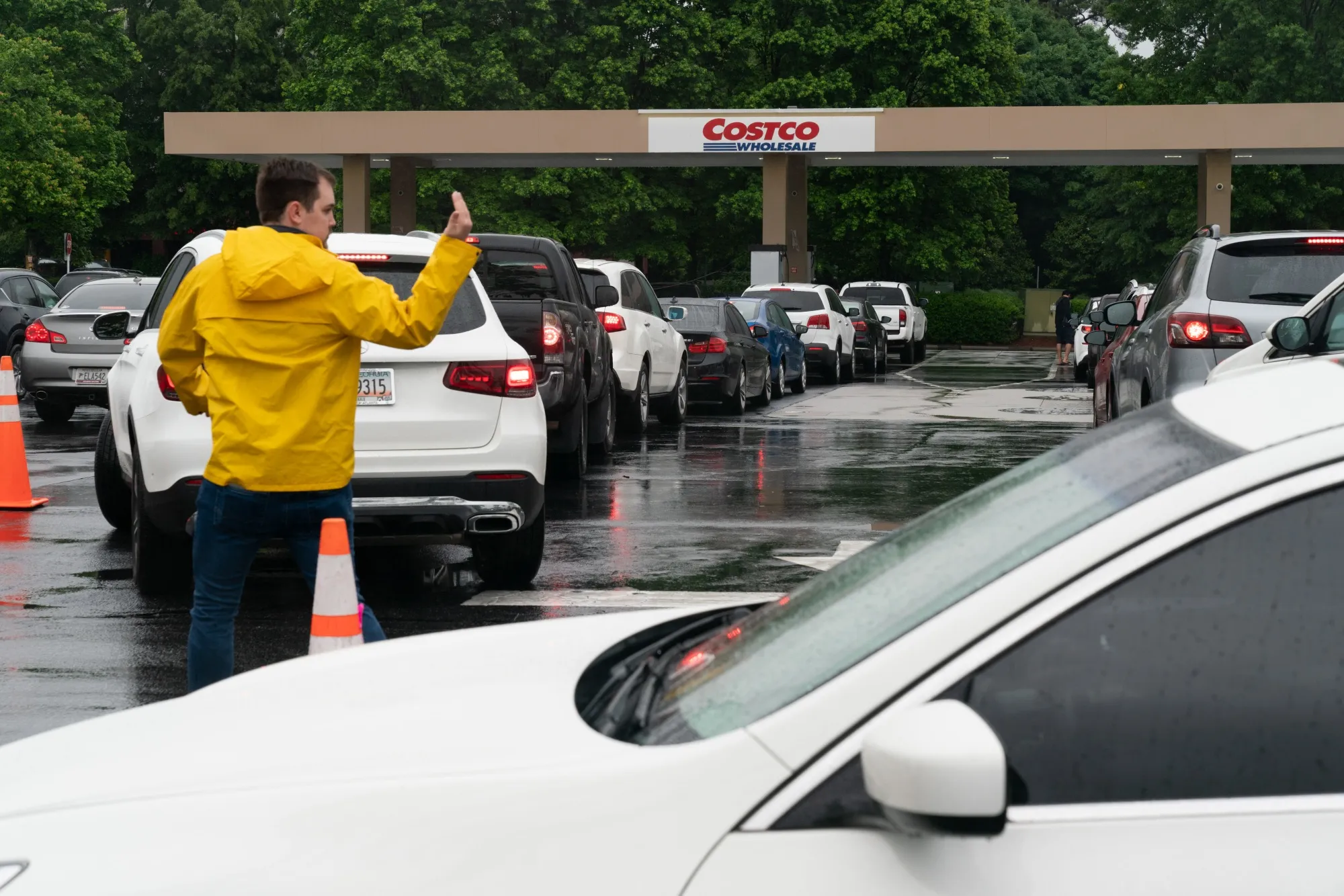 An employee guides drivers waiting in line to refuel vehicles at a Costco Wholesale Corp. gas station in Dunwoody, Georgia on May 12.