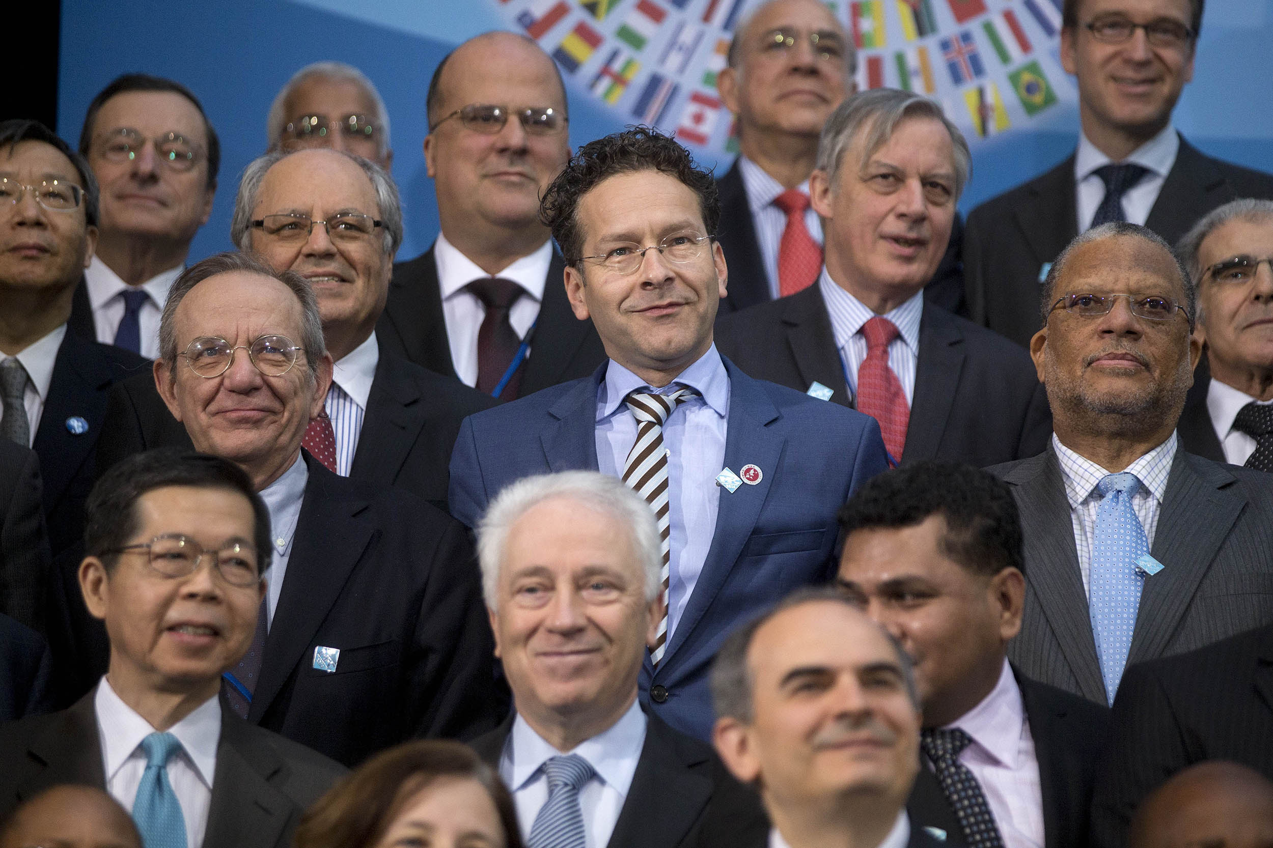 Jeroen Dijsselbloem, Dutch finance minister and president of the Eurogroup, center, and Pier Carlo Padoan, Italy's finance minister, left, attend the International Monetary Fund (IMF) governors family photograph at the IMF and World Bank Group Spring Meetings in Washington, D.C., on April 12, 2014. International central bankers pledged to take care in telegraphing monetary-policy shifts and consider their global effects amid renewed calls from emerging markets for greater cooperation.
