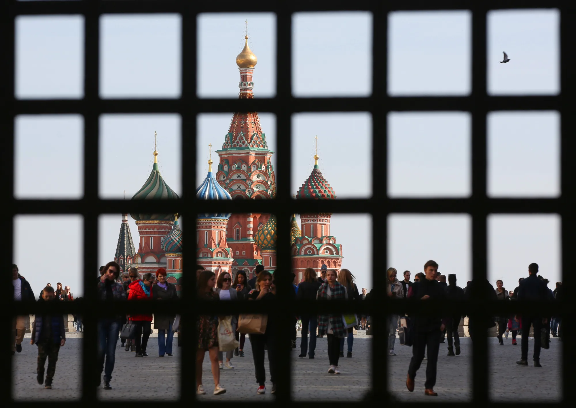 Visitors walk through Red Square near Saint Basil's cathedral in Moscow, Russia.