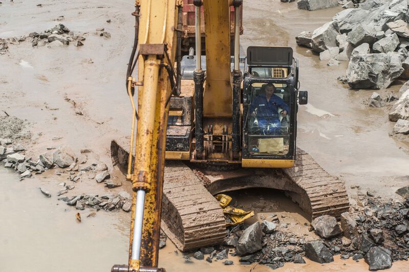 A worker operates a Caterpillar Inc. hydraulic excavator at a ShanDong ZhongJiao Navigation Engineering Co. construction site