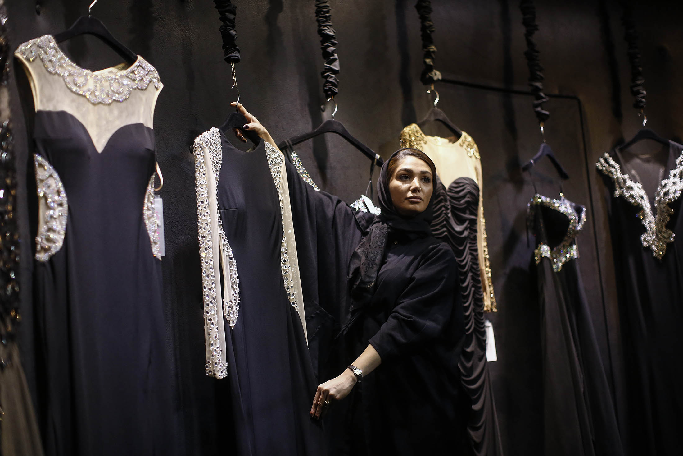 An employee displays a dress at a luxury fashion store inside the Isfahan City Center shopping mall in Isfahan, Iran.
