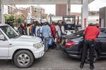 Drivers queue to fill cans with fuel at a gas station in Nairobi, Kenya, on April 13. To try curb inflation and ease pressure on currencies, Kenya and Tanzania have imposed measures, including subsidies on items such as fuel. 