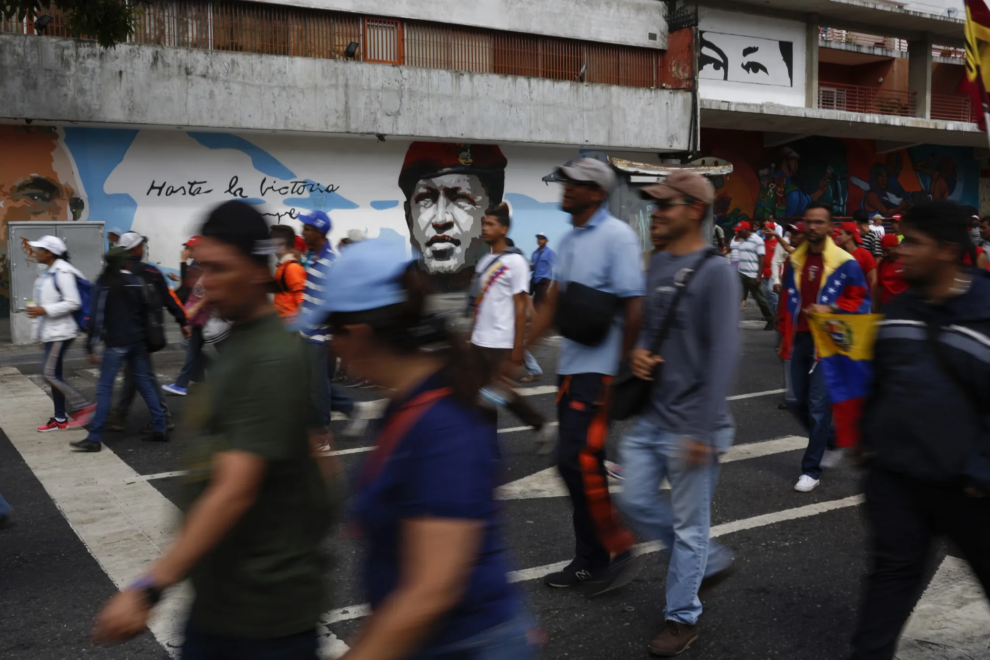 Demonstrators march past a mural of the late Hugo Chavez during a pro-government rally in support of President Nicolas Maduro in Caracas,&nbsp;on&nbsp;Jan. 23.&nbsp;