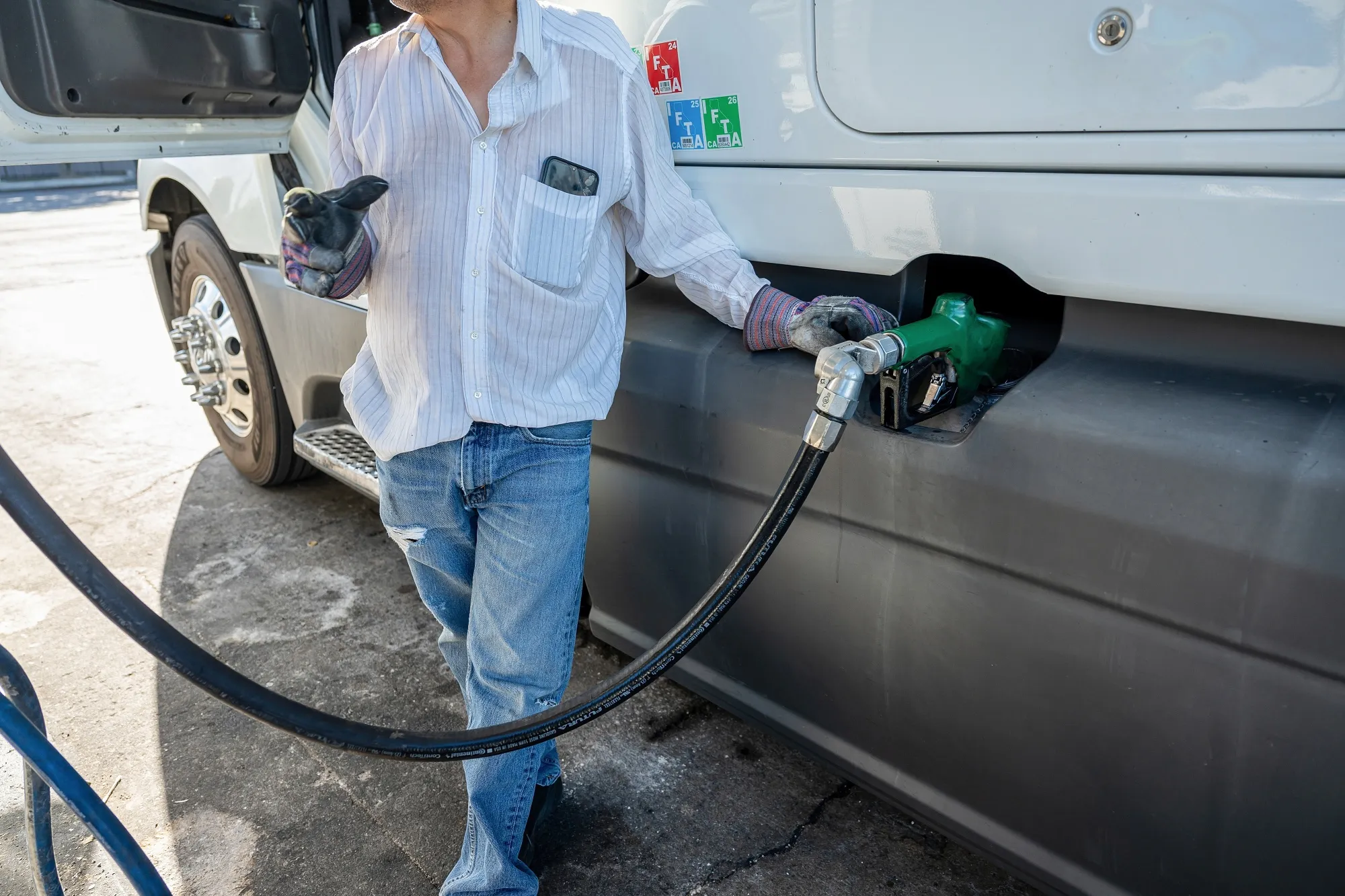 A driver refuels a tractor trailer with diesel fuel at a truck stop in Tracy, California.