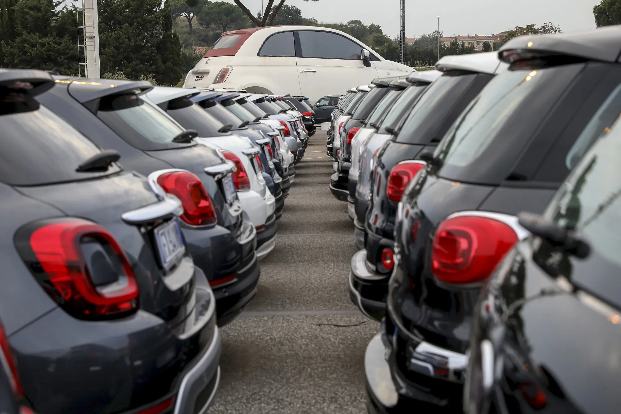 Automobiles sit on the forecourt of a dealership&nbsp;in Rome.