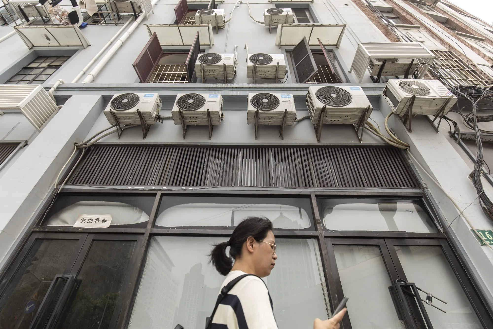 Air conditioners jut from&nbsp;a residential building in Shanghai.