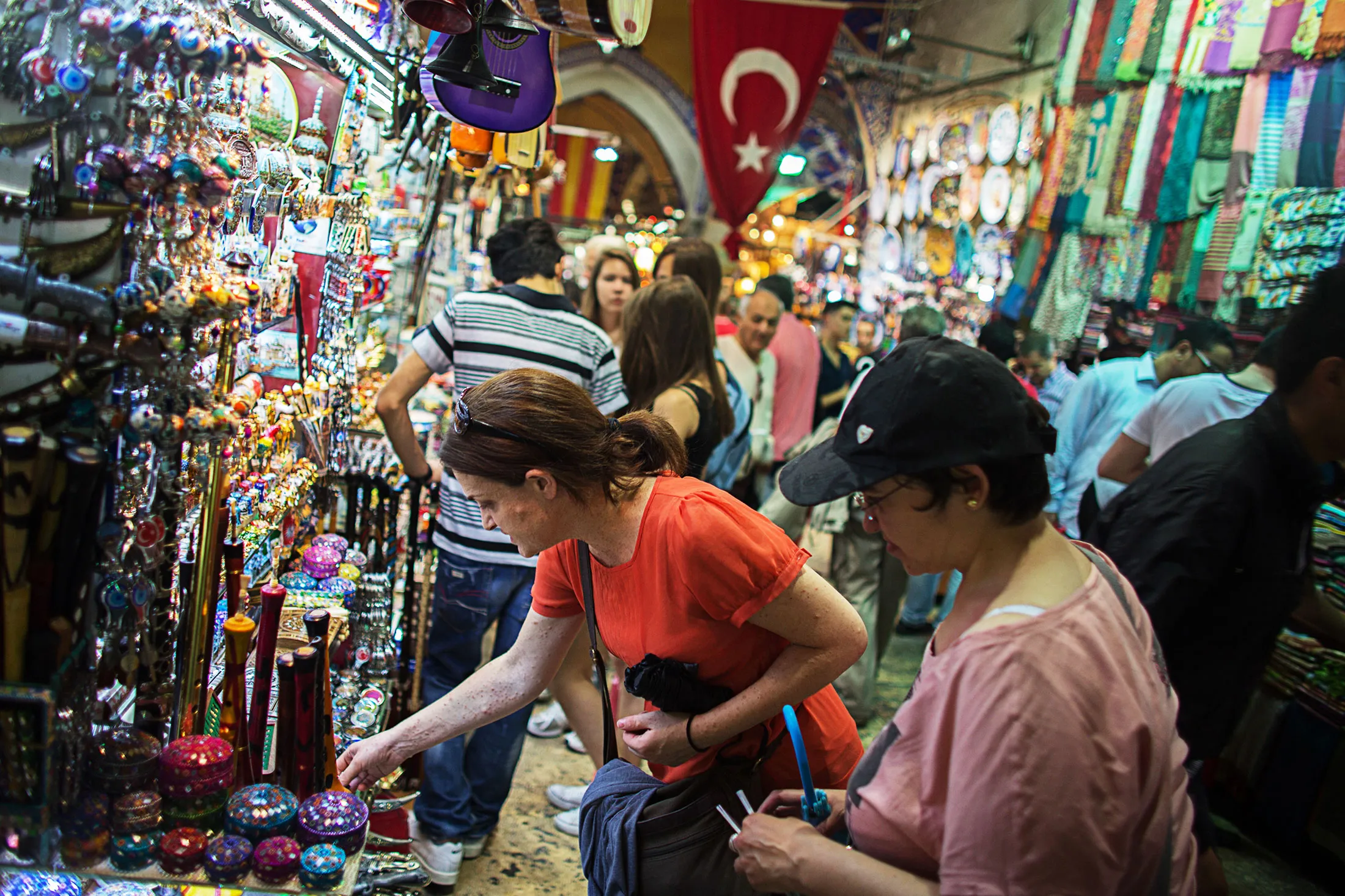 Tourists inspect goods for sale outside a souvenir stores in the Grand Bazaar covered market in Istanbul.
