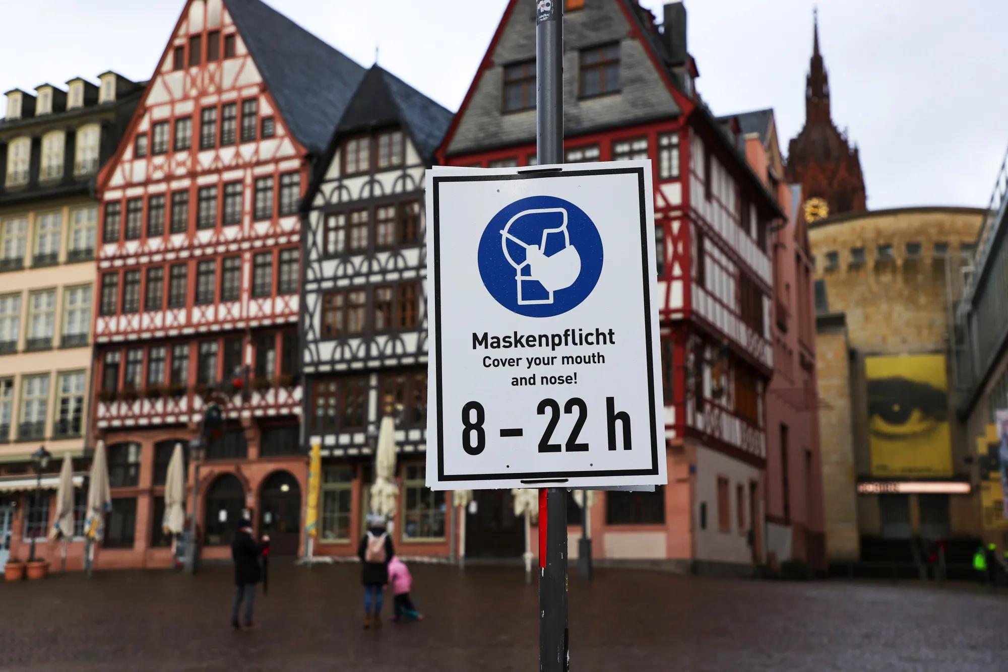 A protective face mask sign in Romerberg Square in Frankfurt.