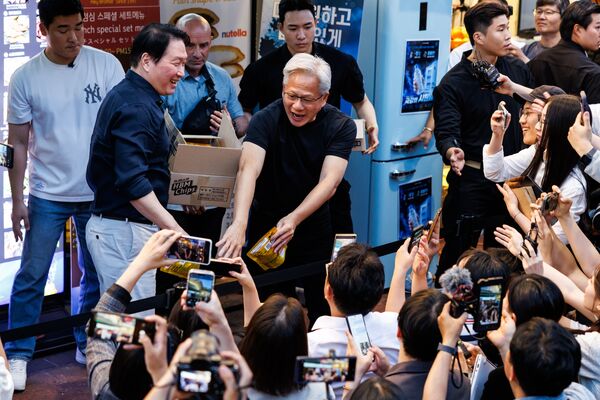 Jensen Huang and Chey Tae-won hand out snacks to members of media outside the restaurant in Hongdae.