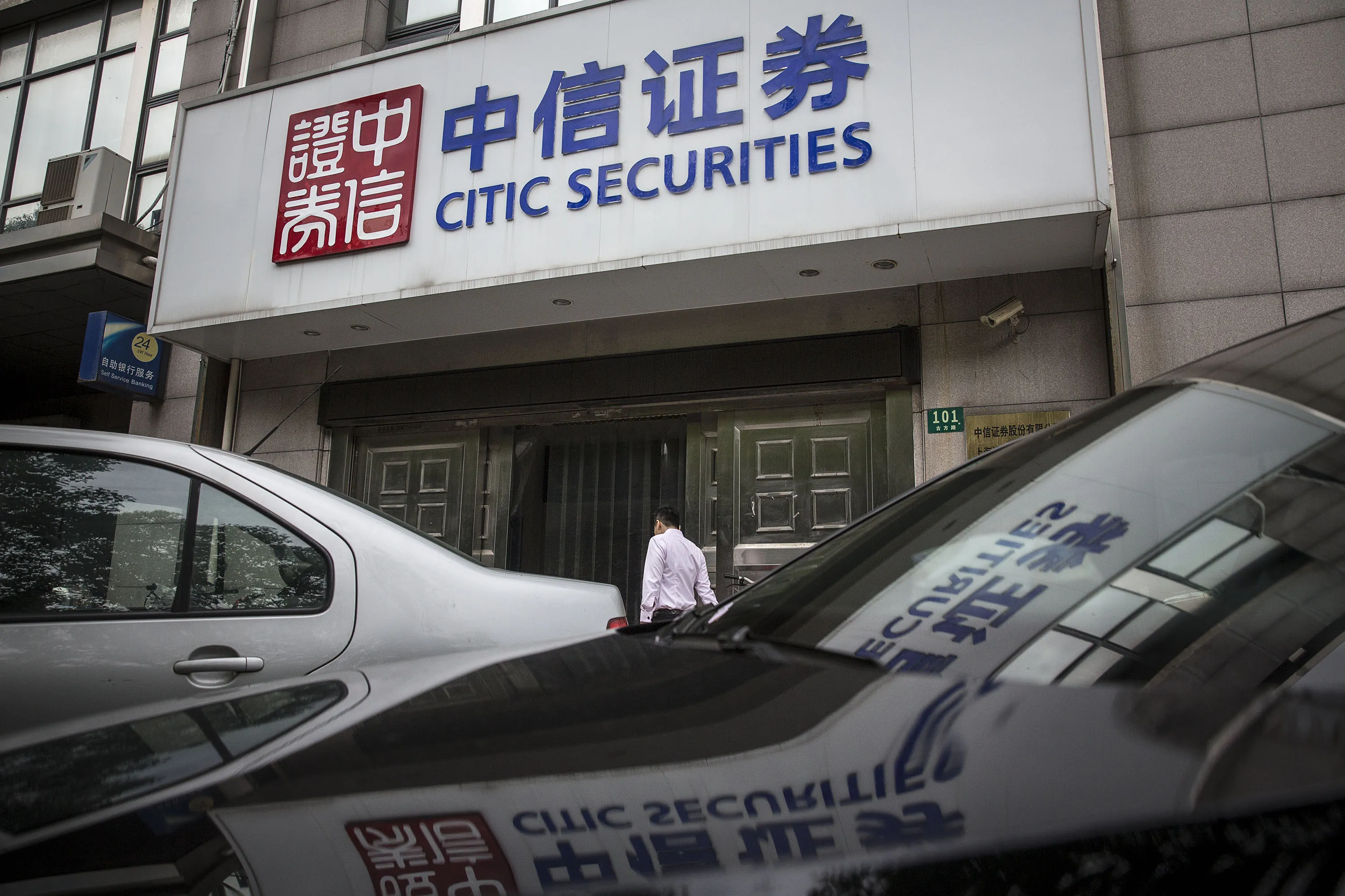 A pedestrian walks past a Citic Securities Co. branch in Shanghai.
