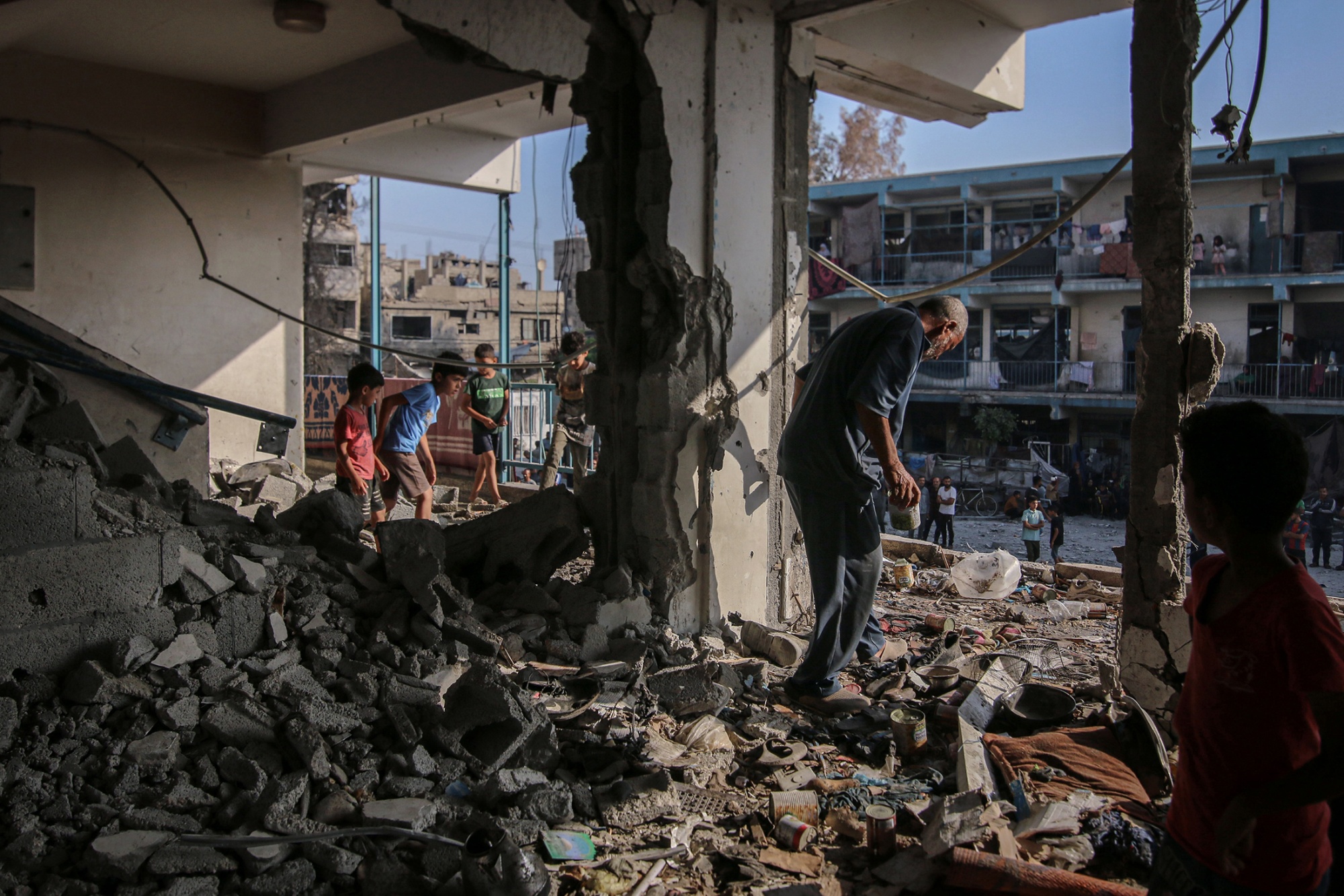 Palestinesi ispezionano i danni subiti da un complesso scolastico per civili sfollati, gestito dall’Agenzia delle Nazioni Unite per il soccorso e l’occupazione, a Nuseirat a giugno. Fotografo: Ahmad Salem/Bloomberg.