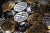 A collection of bitcoin, litecoin and ethereum tokens sit in this arranged photograph in Danbury, U.K., on Tuesday, Oct. 17, 2017. On Wednesday, billionaire Warren Buffett said on CNBC that most digital coins won't hold their value.
