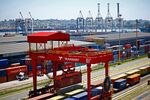 A crane operator unloads shipping containers from freight wagons at the Port of Durban.
