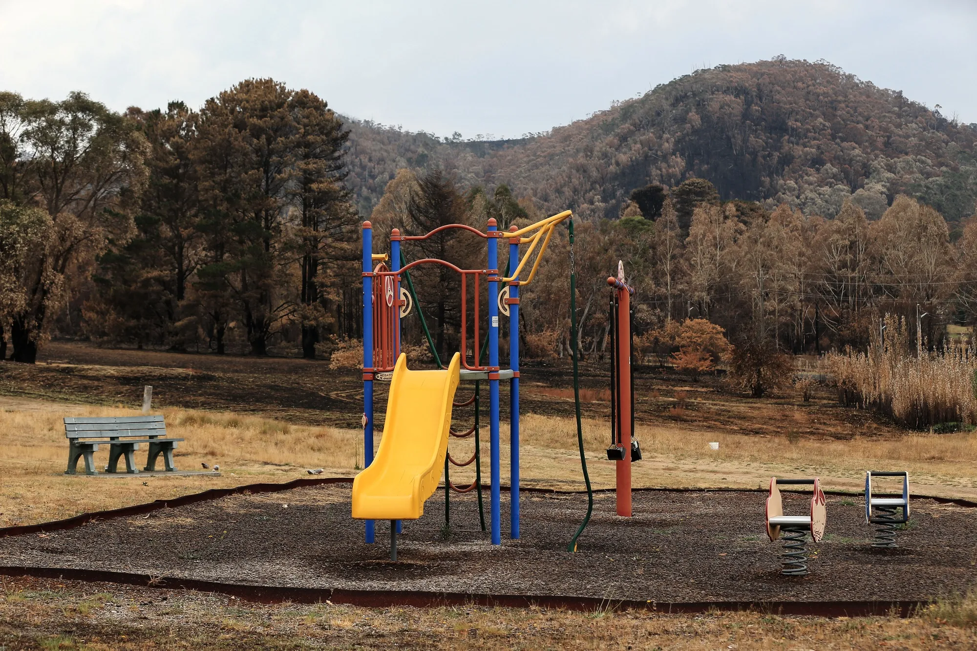 Burned bush land stands beyond a children's playground in Lithgow, New South Wales, on Jan. 7.