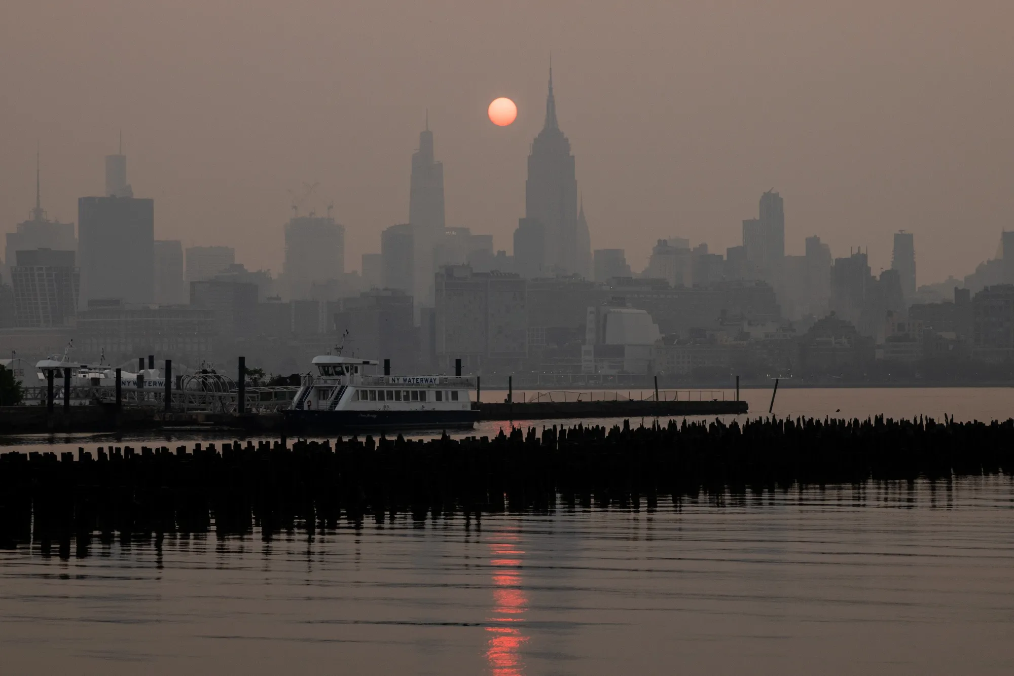 Buildings in the Manhattan skyline shrouded in smoke from Canada wildfires at sunrise on June 7.