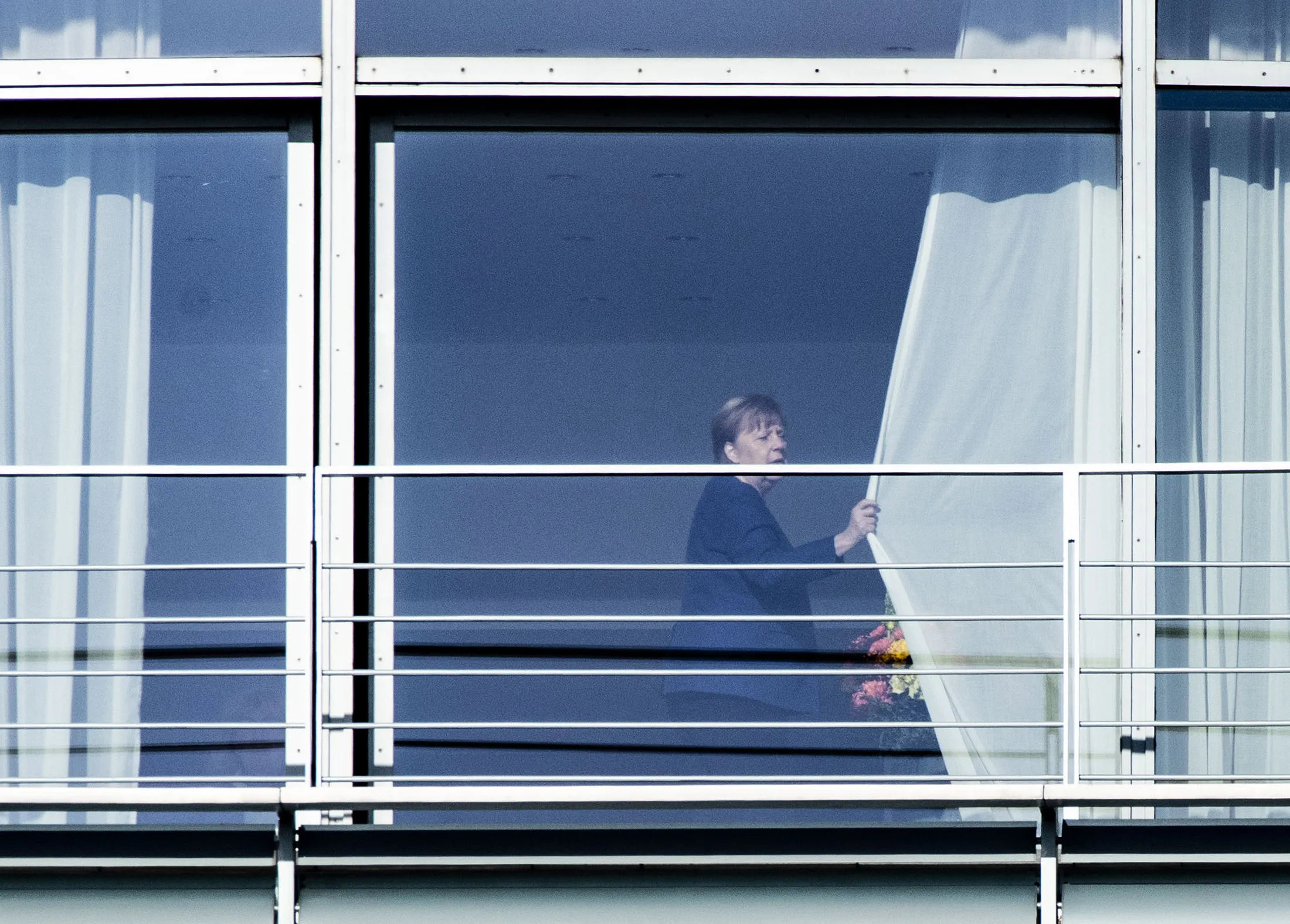 Angela Merkel draws the curtains at the Chancellery before the start of a coalition committee on Feb. 8.