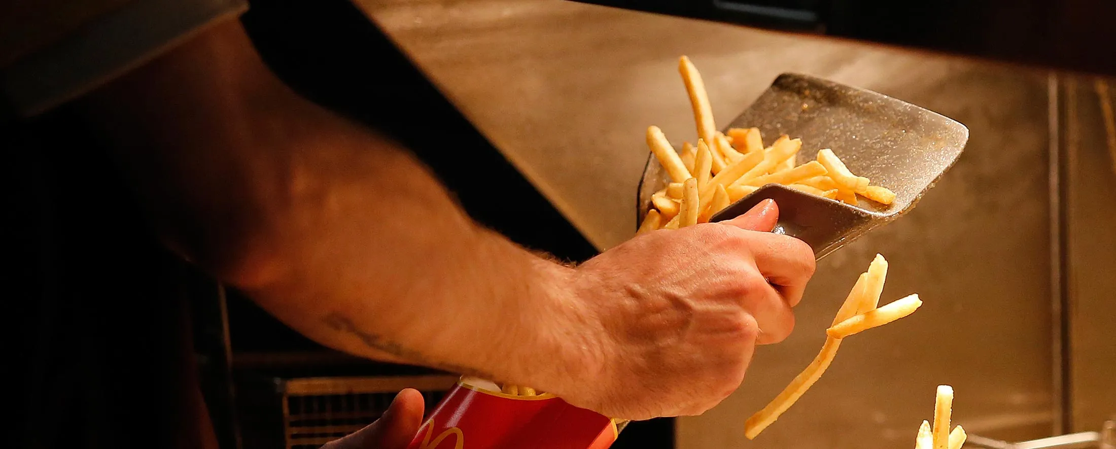 An employee scoops fries into a carton inside a McDonald's Corp. restaurant in Manchester, U.K., on Monday, Aug. 10, 2015. McDonald's Chief Executive Officer Steve Easterbrook predicted a return to growth for the burger chain in the second half of the year, giving investors cause for optimism after another quarter of slumping sales.
