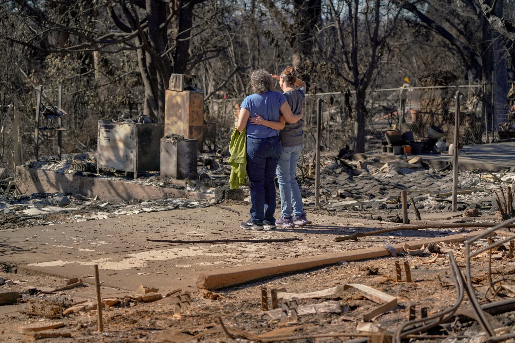 People embrace at their childhood home, destroyed by the Eaton Fire in Altadena, California, on Jan. 23, 2025.&nbsp;