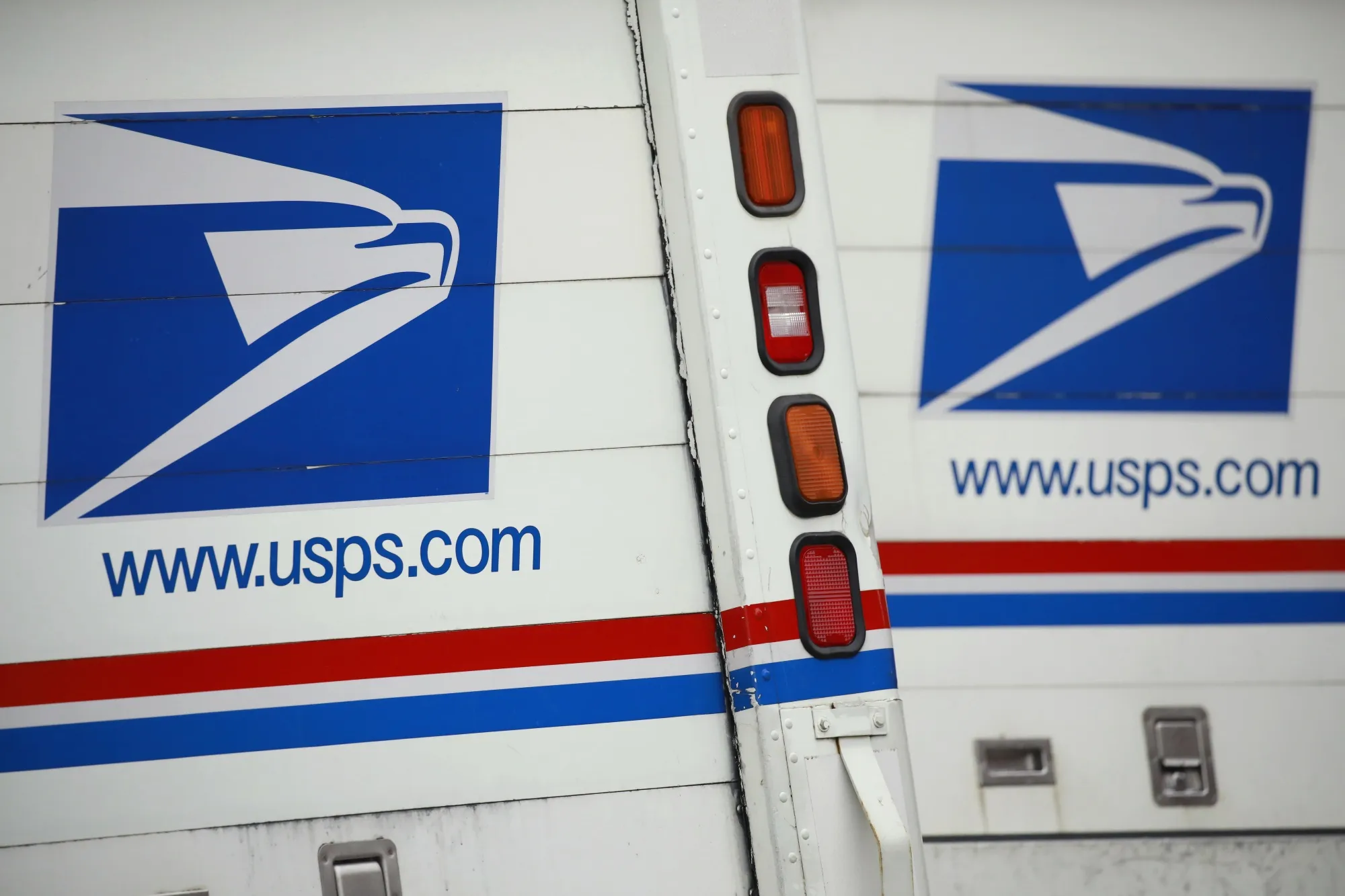 Mail delivery vehicles parked outside a USPS distribution center in Chicago, Illinois.