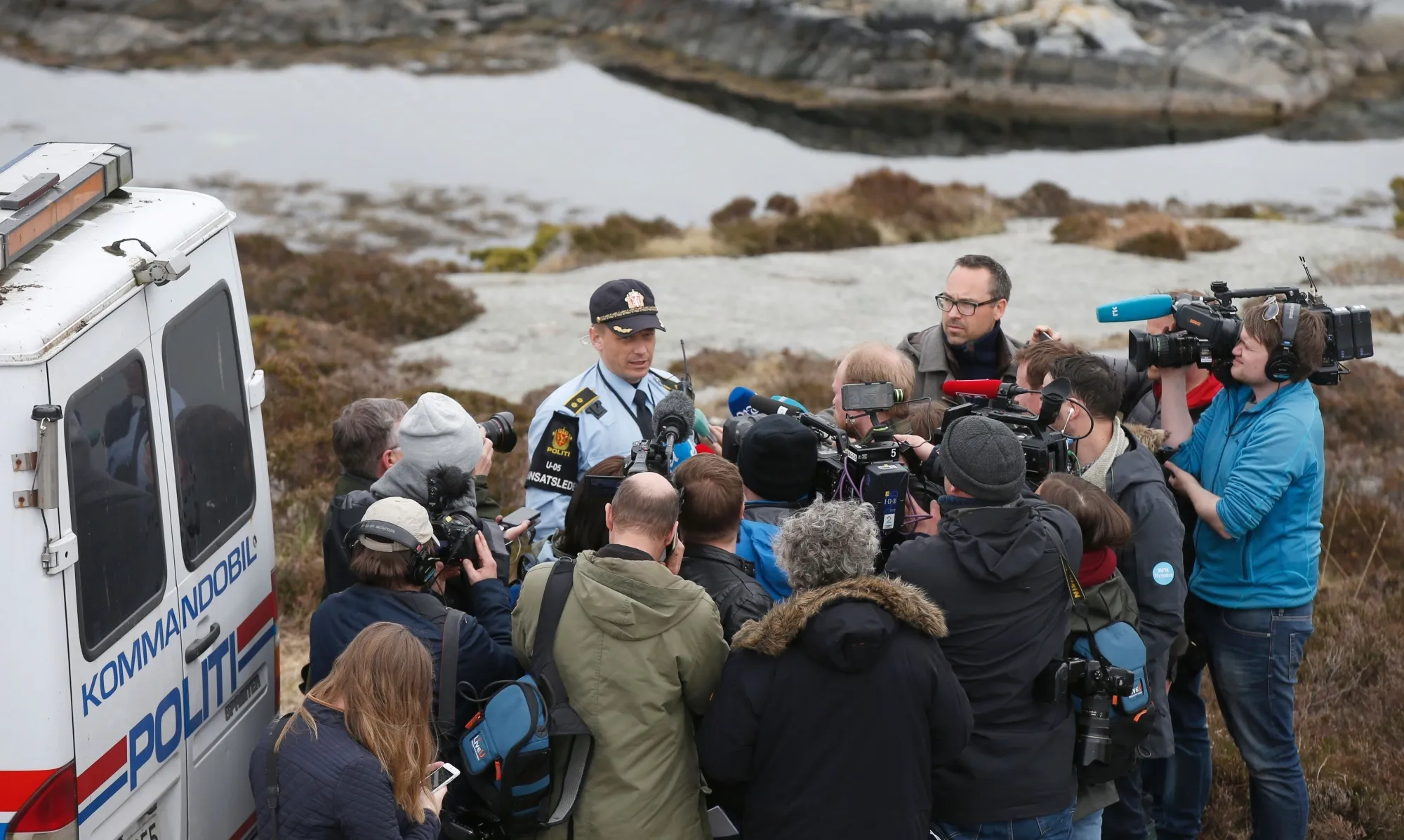 A Policemen talks to media near the crash site on the island Turoy on Saturday.

