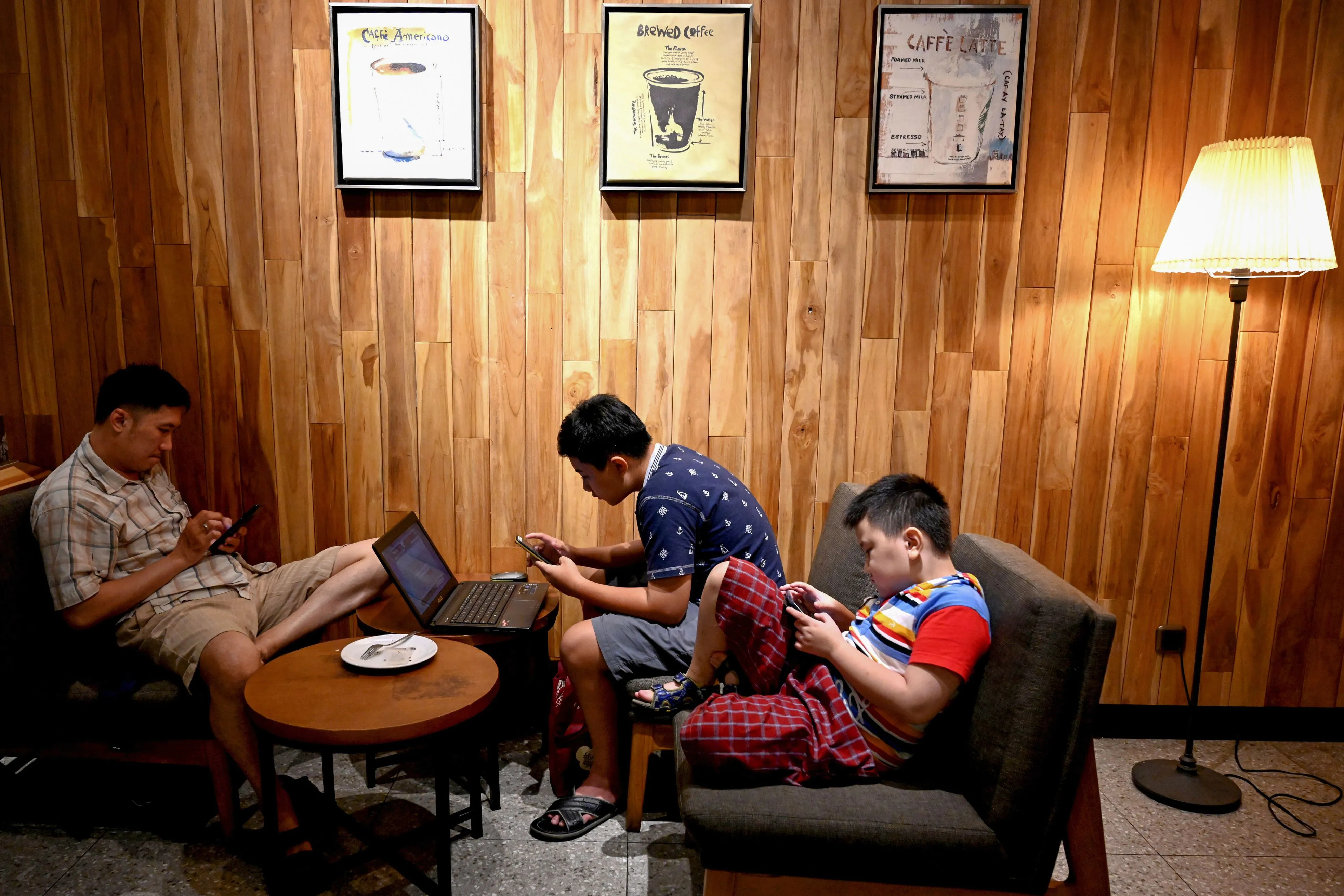 Customers wait for their coffee at a cafe in Jakarta.