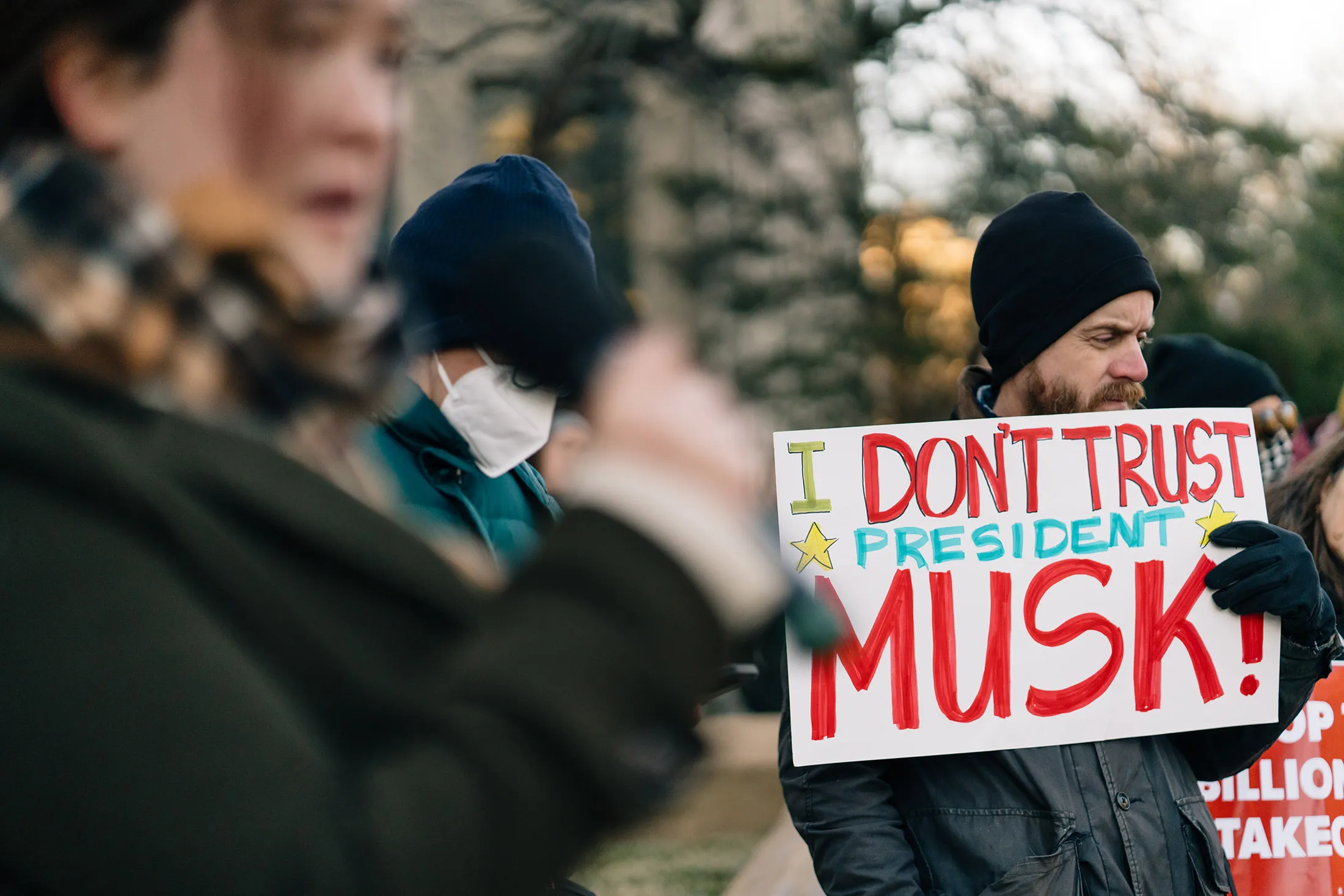 Miles Townes, a substitute teacher from Arlington, Virginia, holds a sign as demonstrators rally in support of federal workers and against Elon Musk and DOGE outside the Office of Personnel Management in Washington on Feb. 7.