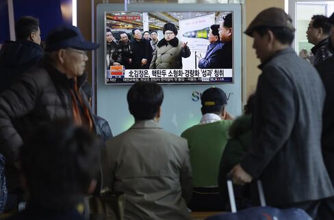 People watch a TV news program showing North Korean leader Kim Jong Un in Seoul on Wednesday. The North Korean leader has said that his country would retaliate with nuclear missiles if it is attacked by the U.S. and South Korea.