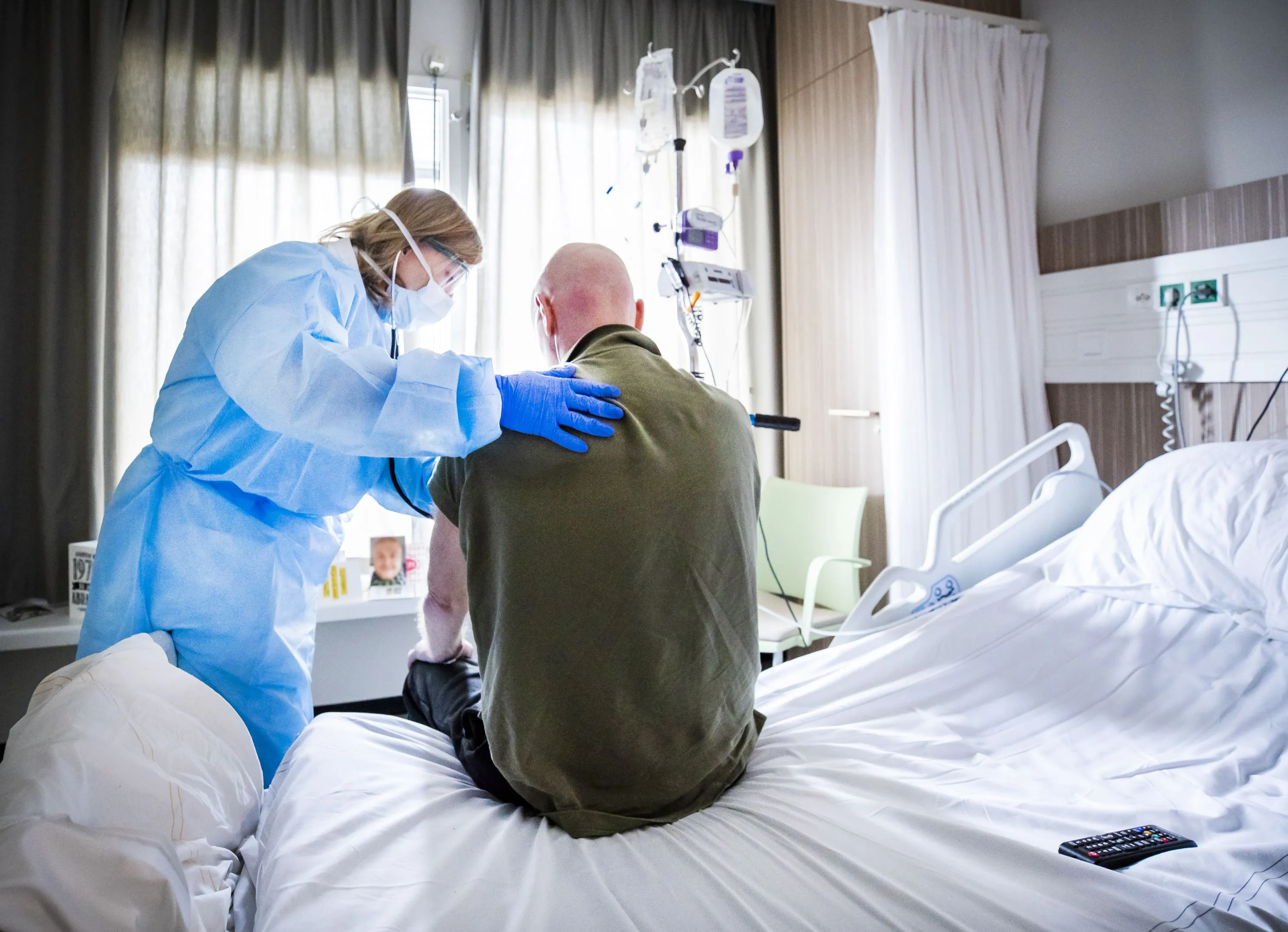 An attending physician listens to the breathing of a Covid-19 patient who is recovering.
