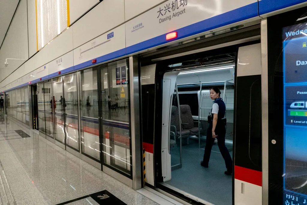 A train waits at the platform of Daxing airport station.