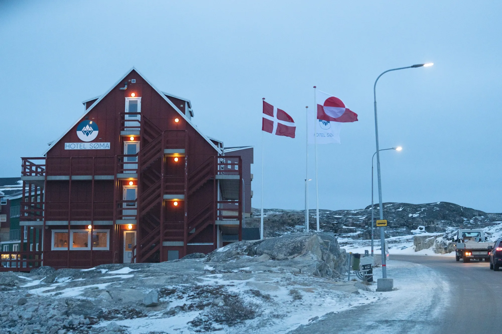 The flags of Denmark, left, and Greenland fly side-by-side in Ilulissat, Greenland.