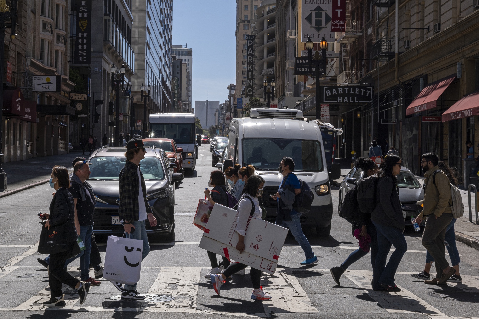 Pedestrians carry shopping bags on Powell Street in San Francisco.