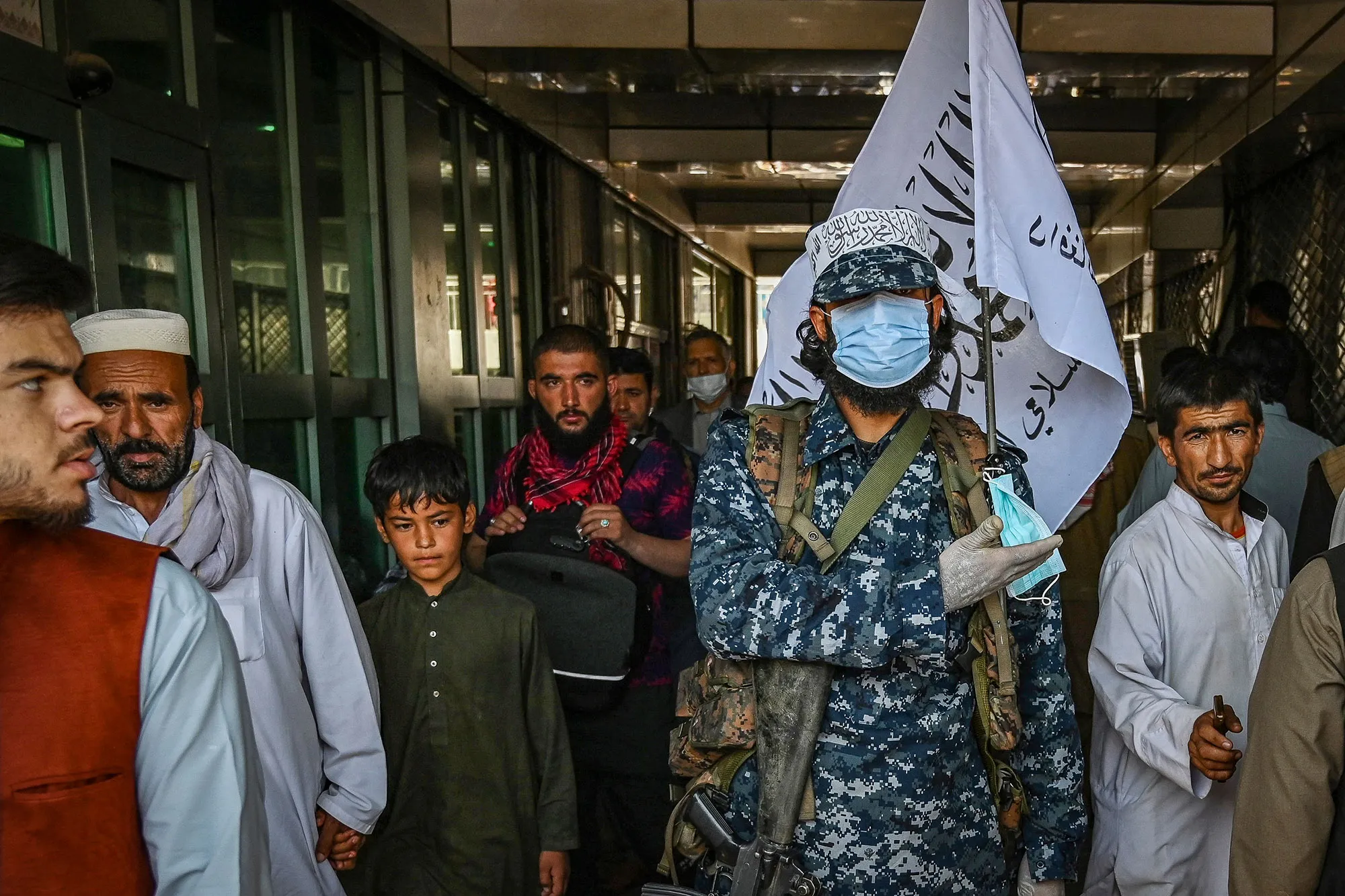A Taliban fighter stands guard at a market in Kabul.
