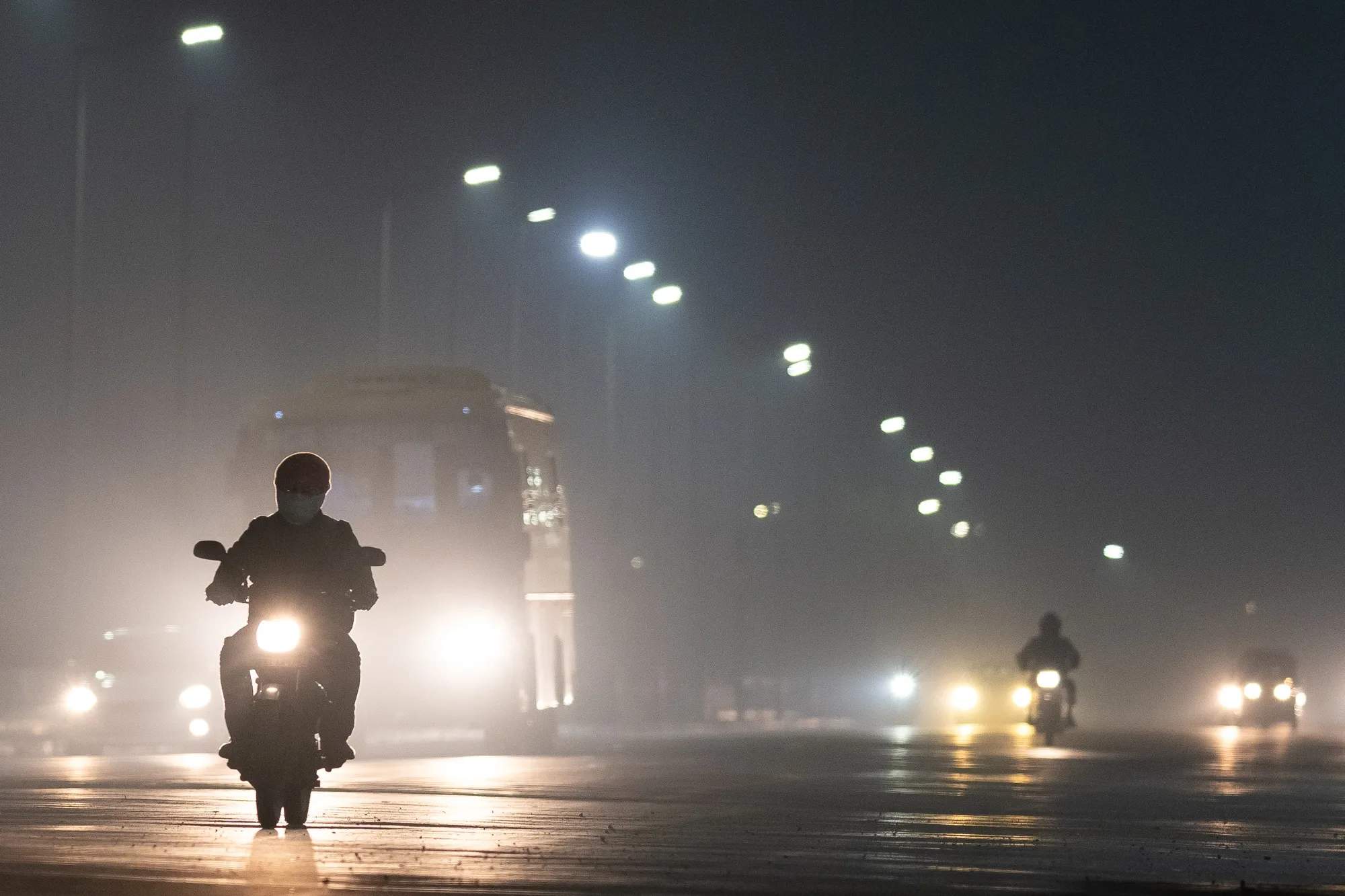 Commuters make their way along a road on a hazy morning caused by pollution in New Delhi on Dec. 3.