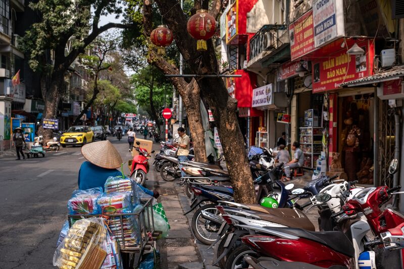 A street vendor pushes a bicycle along a road in the old quarter in Hanoi, Vietnam, on Tuesday, March 21, 2023. Vietnam is scheduled to release it's annual gross domestic product (GDP) figures on March 29.