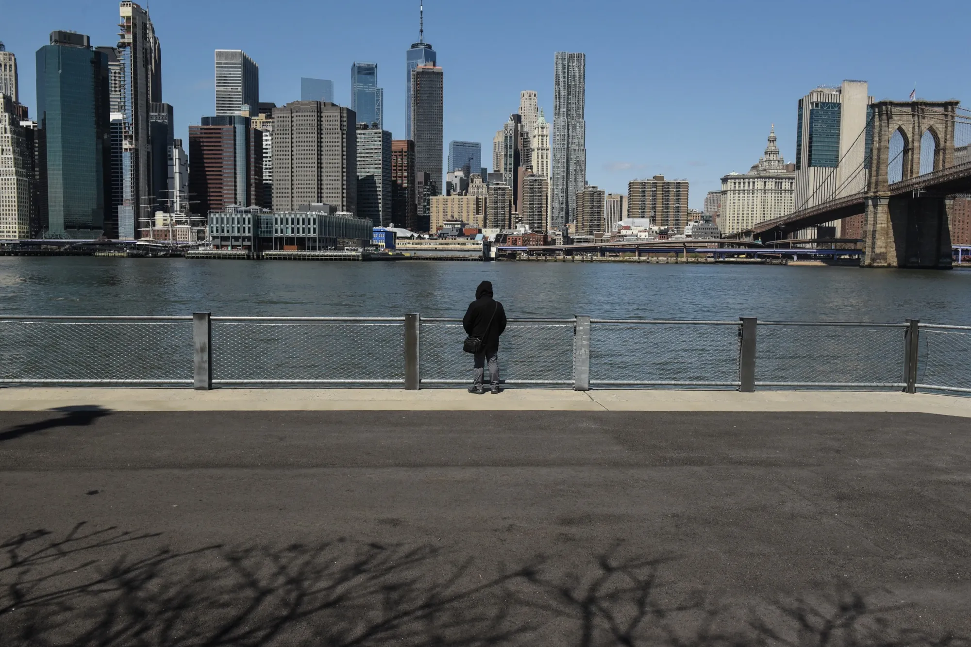 A person stands at Brooklyn Bridge Park in the Brooklyn Borough of New York.