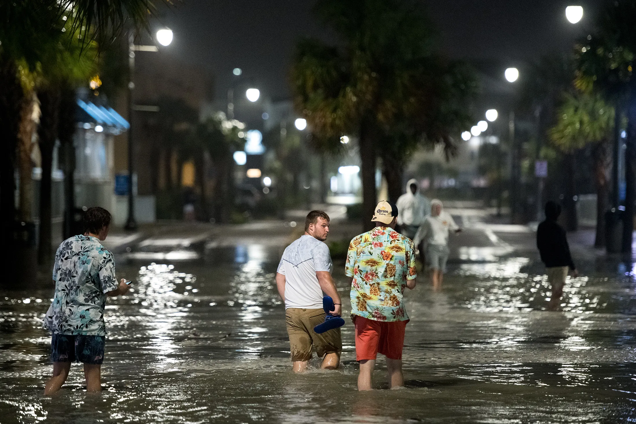 People walk through floodwaters on Ocean Blvd. in Myrtle Beach, South Carolina on Aug. 3.&nbsp;