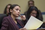 Representative Alexandria Ocasio-Cortez listens as the lawyer Michael Cohen appears before the U.S. Congress to answer questions.