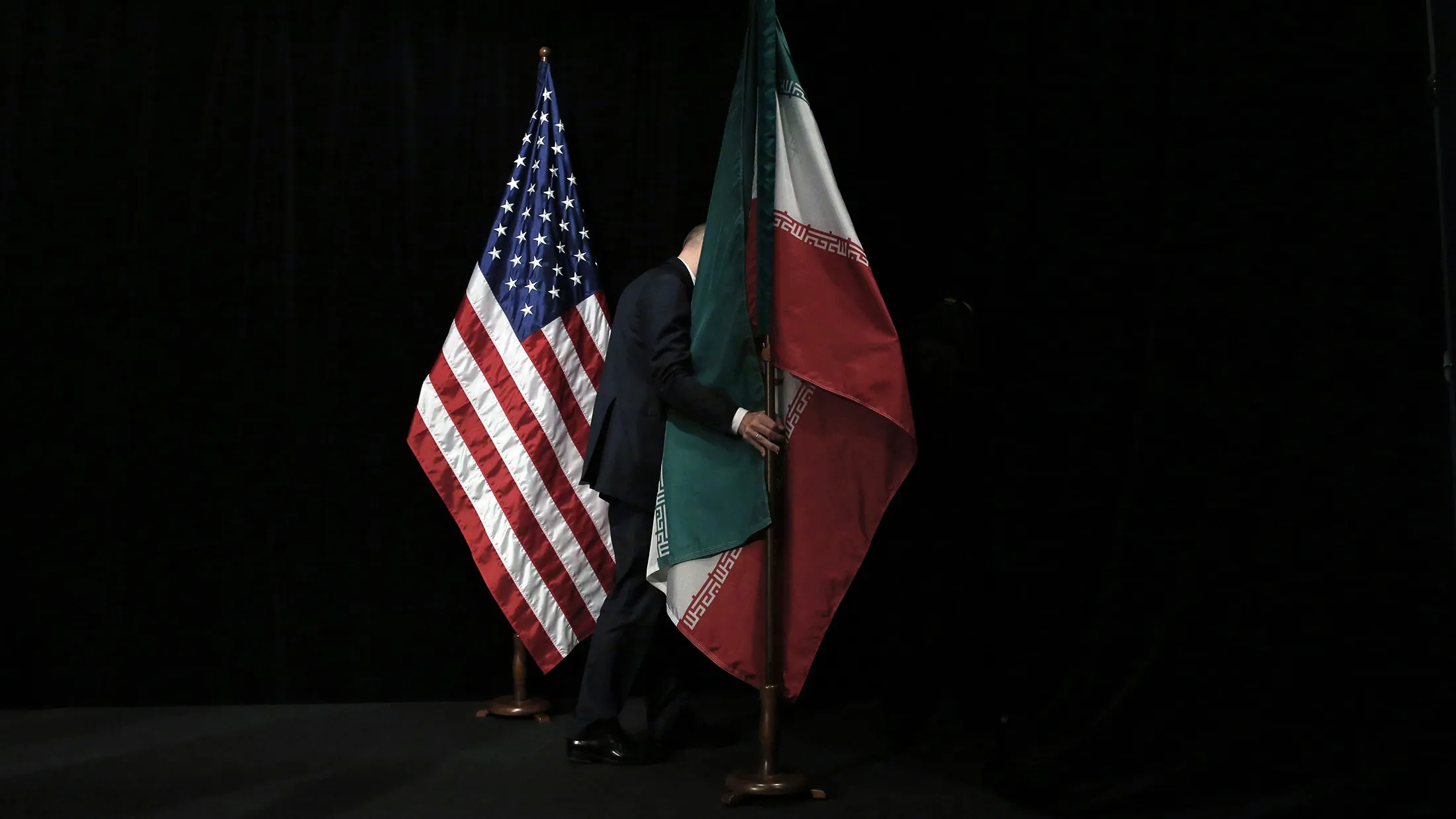 A staff member removes the Iranian flag from the stage after a group picture of foreign ministers and representatives of the U.S., Iran, China, Russia, Britain, Germany, France, and the European Union during the Iran nuclear talks at the Vienna International Centre on July 14.
